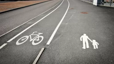 Bike land and pedestrian lane marked with white paint on grey asphalt