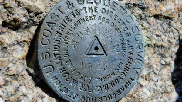 Metal U.S. Geodetic Survey marker in stone in Arizona.