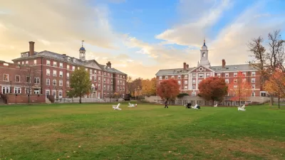View of wide green lawn in front of red brick four-story buildings on Harvard University campus