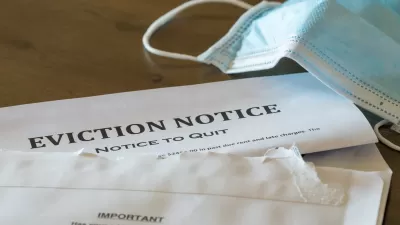 Eviction notice on table with surgical face mask lying next to it.