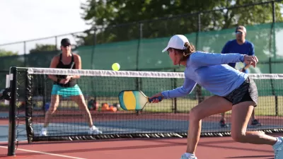 Four people playing pickleball on outdoor court