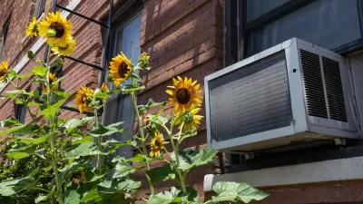 air conditioner unit on brick building wiht sunflowers.