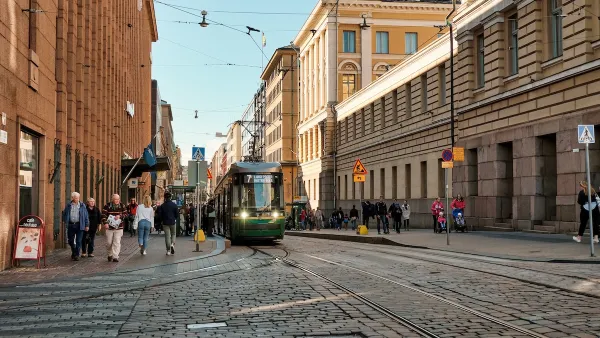 Street scene in Helsinki, Finland with people and streetcars.
