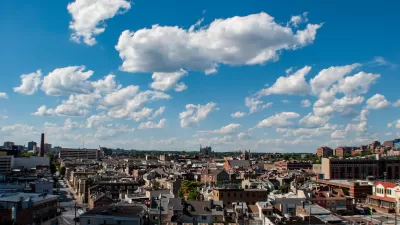 View of east Baltimore, Maryland low-slung brick buildings against a lightly cloudy blue sky