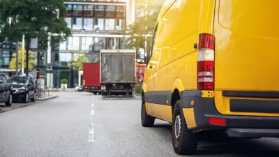 View from rear of yellow delivery van on city street.