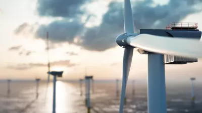 Close-up of offshore wind turbine with other turbines in background.
