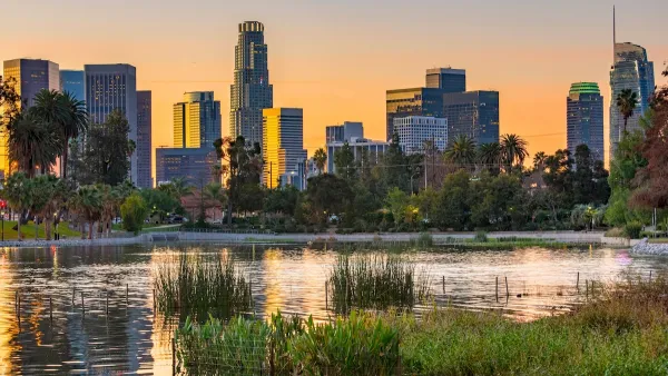 Park pond at sunset with Los Angeles skyline in background.