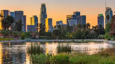 Park pond at sunset with Los Angeles skyline in background.