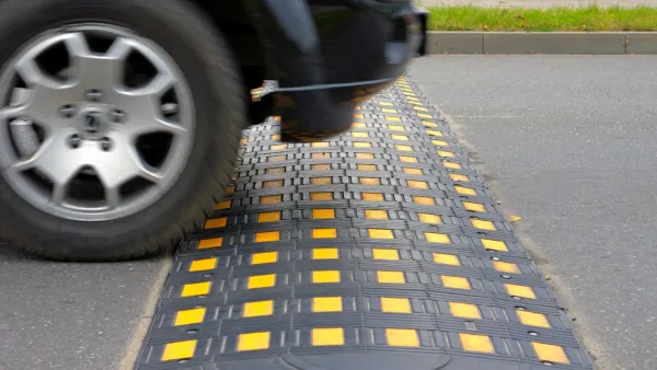 Black and yellow speed hump on road.