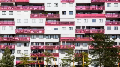Multistory apartment building facade in Vienna, Austria with pink glass balconies.