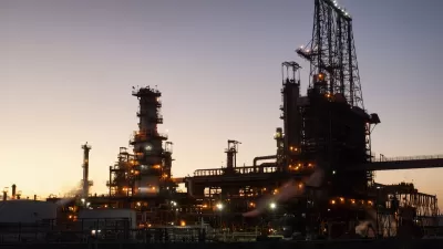 Oil refinery sillhouetted against evening sky.