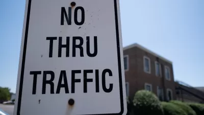 Close-up of white "No Thru Traffic" sign