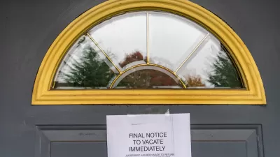 Eviction notice taped to dark grey door with arched window at top.
