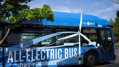 Blue electric bus labeled with 'All-Electric Bus Wind Powered by PGE' in white in Tigard, Oregon.