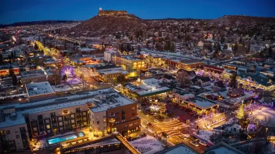 Aerial view of Castle Rock, Colorado at dusk in winter with Christmas lights.