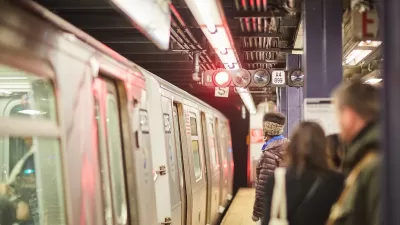 People waiting to board subway train on platform in New York City.