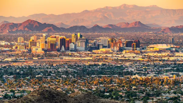 Skyline of Phoenix, Arizona with mountains in background at dawn or dusk.