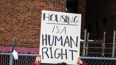 Close-up on handmade sign being held up at protest "Housing is a human right"