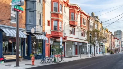 Row of three-story buildings with stores and restaurants with awnings on ground floor in Philadelphia, Pennsylvania.