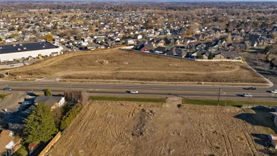 Aerial view of graded dirt lot ready for construction and houses with mountains in background near Boise, Idaho