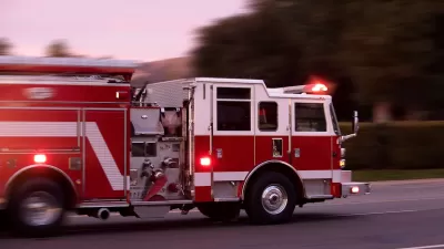 Red fire truck speeding down a street.