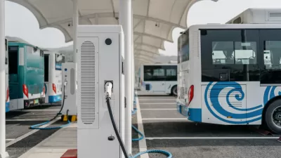 White electric tranasit bus plugged into a charging station