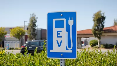 Blue sign with white gas pump symbol with electric plug and "EV"