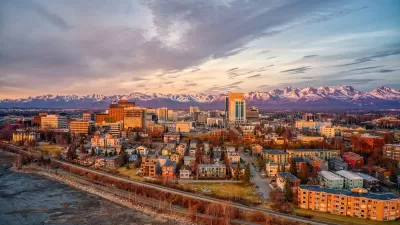 Aerial view of Anchorage, Alaska downtown with mountains in background at golden hour.
