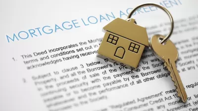 Close-up on mortgage application terms and house-shaped gold keychain with gold key on it.