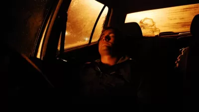 Person sleeping in car at night.