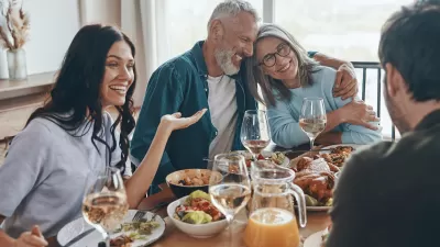 Multi-generational white family sits around dining table