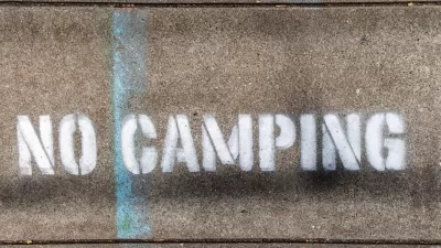 "No Camping" stencil on concrete.