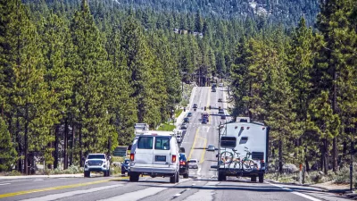 Road with traffic near Lake Tahoe, California with pine tree forest on either side.