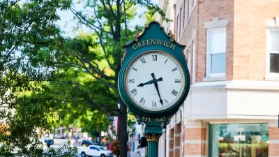 Close-up of green ornate clock with Greenwich written in gold on street in downtown Greenwich, Connecticut.