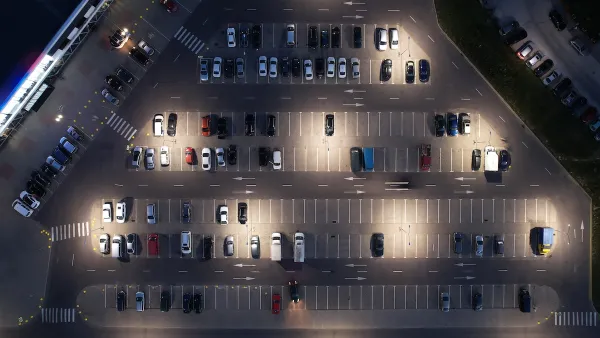 Bird's eye view of half full parking lot at night.