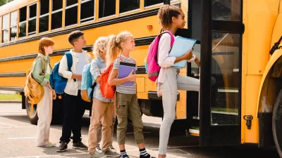Children boarding yellow school bus.