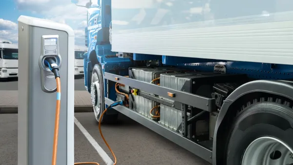 Electric 18-wheeler truck plugged into electric charger.