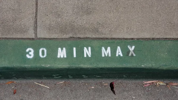 Close-up on green painted curb with '30 min max' in white. 