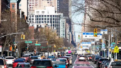 Busy New York city street with red painted bus-only lane on right.