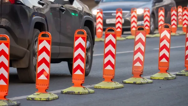 Orange and white plastic bollards delineating bike lane.