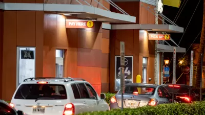 Line of cars at a McDonald's drive-thru at night.