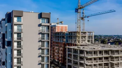 Multistory buildings under construction in a dense city with cranes.