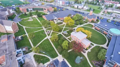 Aerial view of college campus with red brick buildings and green lawns.