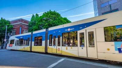 White and blue TriMet MAX light rail train on street in Portland, Oregon.