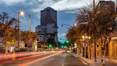 Street with blurred traffic and office buioldings in background in Tucson, Arizona at dusk.