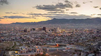 Aerial view of El Paso, Texas at dusk with mountains in background.