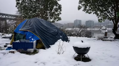 Blue tent with small charcoal grill and plastic bin set up by unhoused person in snow in Portland, Oregon.