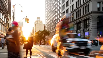 Fast paced scene with people bike and cars at the busy intersection of 14th Street and 5th Avenue in New York City.