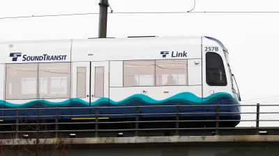 White and blue Sound Transit light rail train on elevated rail in Seattle, Washington.