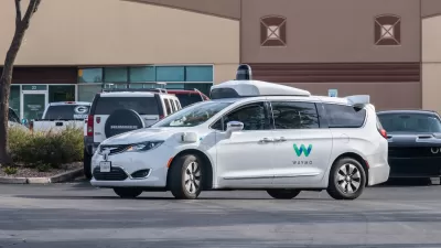 White Waymo self-driving car in parking lot in Chandler, Arizona.